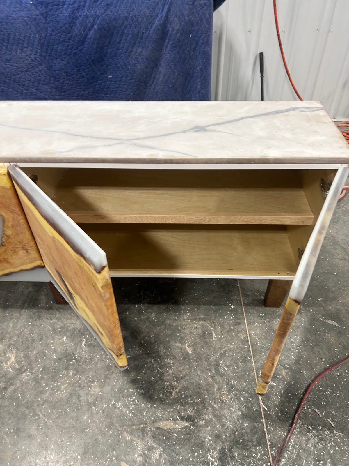 Open media console cabinet showing interior shelving