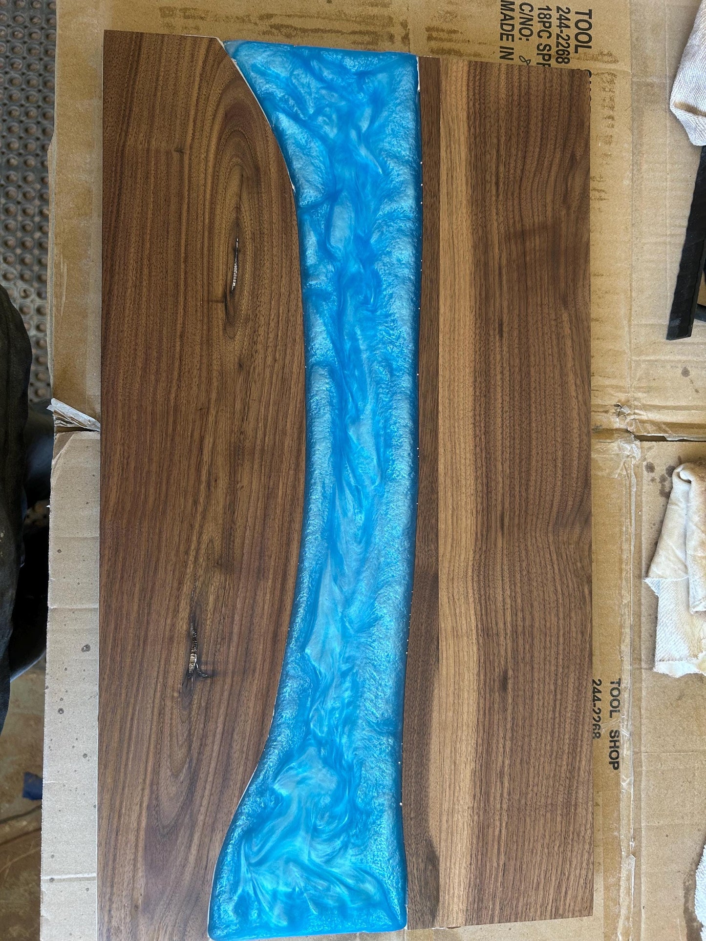 Wooden surface with a blue resin overlay on cardboard packaging