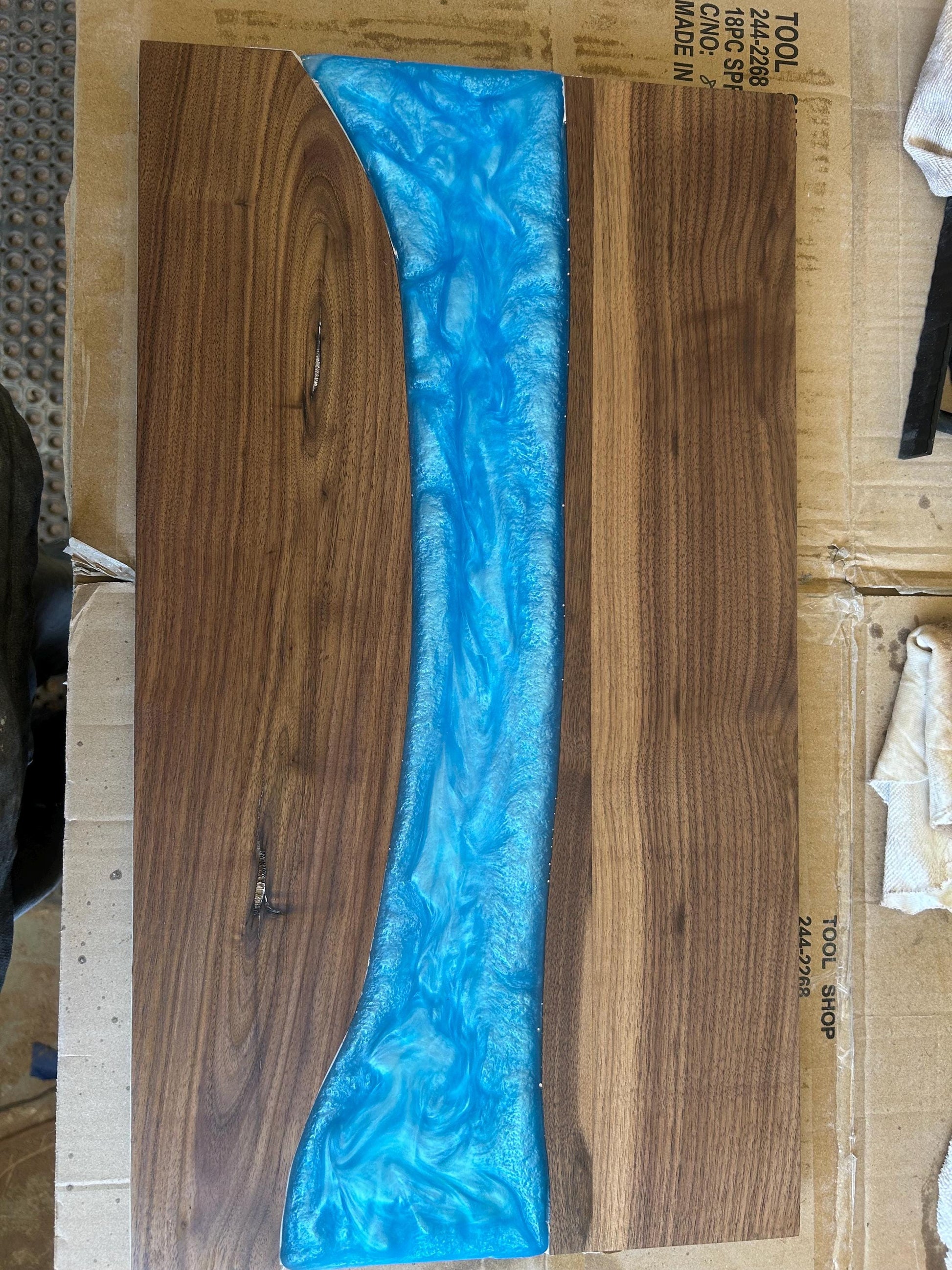 Wooden surface with a blue resin overlay on cardboard packaging