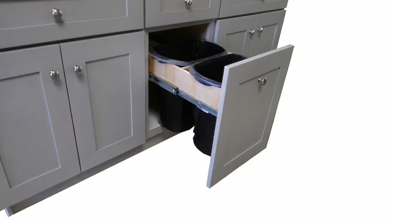 Gray cabinet with a drawer open showing trash bins inside